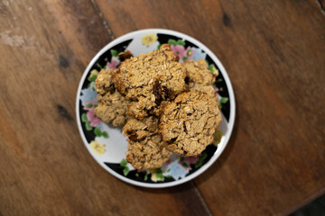 cookies, oatmeal cookies resting over a little dish plate, on a wooden table