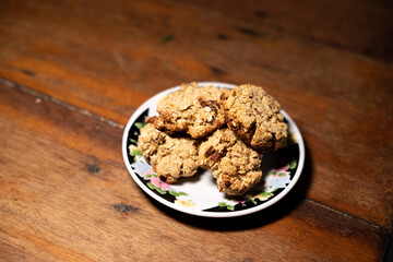 cookies, oatmeal cookies resting over a little dish plate, on a wooden table