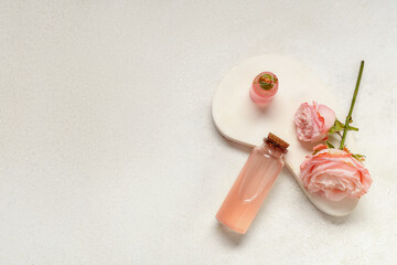 Composition with bottle of cosmetic oil, plaster stand and roses on light grunge background