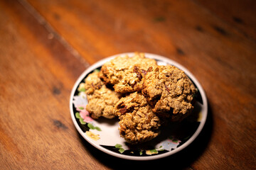 cookies, oatmeal cookies resting over a little dish plate, on a wooden table