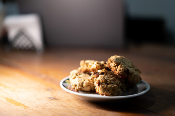 cookies, oatmeal cookies resting over a little dish plate, on a wooden table