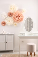 Beautiful decorative paper flowers on wall in room
