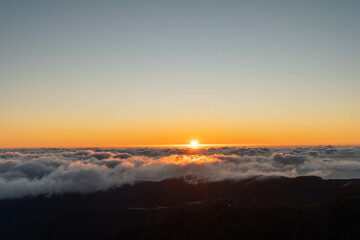 Sunset Above the Clouds Over Mountain Peaks