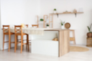 Candles on wooden table in modern kitchen. Blurred view
