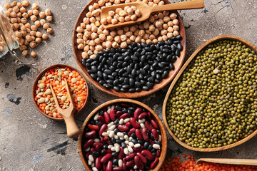 Composition with different raw legumes on grunge background