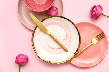 Stylish table setting with beautiful rose flowers on pink background