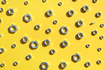 Many chrome nuts on yellow background
