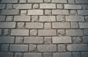 Close-up shot shows cobblestone sidewalk, old weathered surface. Grey, brown colors. Square paving stones brick texture, creating urban background. Grunge, vintage aesthetic, perfect for backgrounds.
