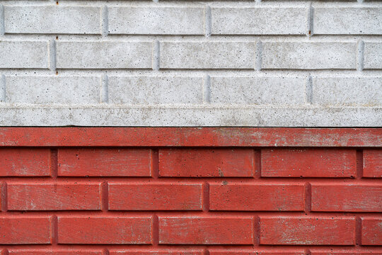 Fototapeta Mur z czerwonej i szarej cegły – kontrast materiałów – Surowa architektura i miejskie detale.