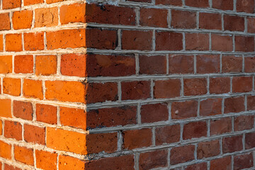 Ceglana ściana na rogu budynku, tekstura cegieł w ciepłym świetle   © Kacper