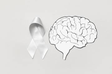Paper brain with awareness ribbon on grey background. Cancer concept