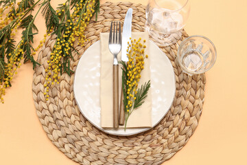 Beautiful table setting with mimosa flowers on orange background