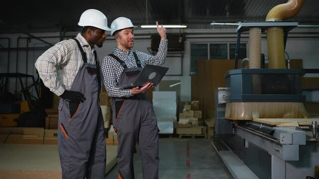 Two Engineers Discuss MDF Cutting on Laptop at Furniture Factory