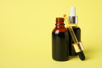 Bottles with iodine and pipette on yellow background, closeup