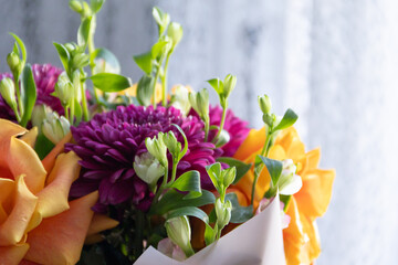 lilac dahlias with yellow roses in a bouquet on a light background close-up. bouquet of dahlias and roses