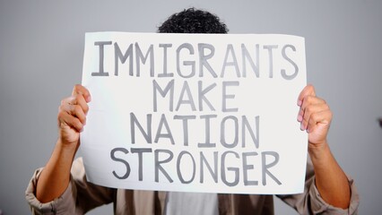 Hispanic man holding sign supporting immigrants