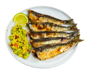 Delicious grilled sardines with guacamole and lemon. Isolated over white background