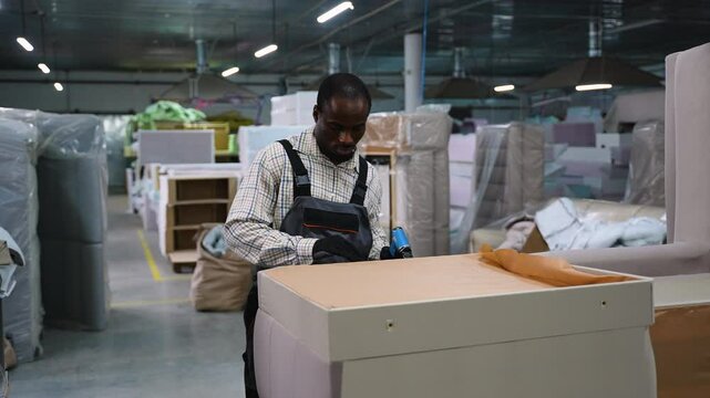 Upholsterer Securing Fabric to Sofa Base with Staple Gun
