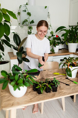 Teenage girl caring for her indoor plants with a watering can.