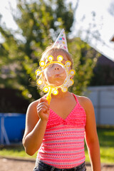 Girl blowing soap bubbles outdoors at sunset, surrounded by golden sunlight