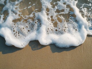 Clear sea water with white foam at the sandy beach