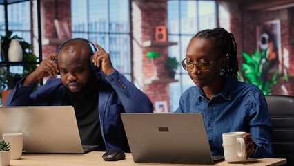 African american man and woman working remotely in their apartment, planning business strategies...