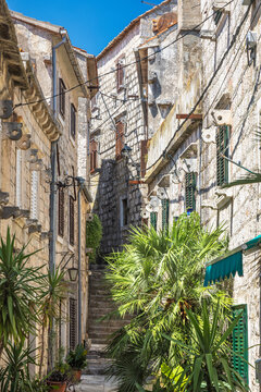 Orebic town at coast of the Peljesac peninsula in Croatia, Europe. Charming old town alleyway with stone buildings, stairs, and lush greenery, showcasing European architecture and a sense of history.
