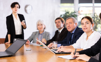 Group of diverse business people attending meeting in conference room, discussing work plan