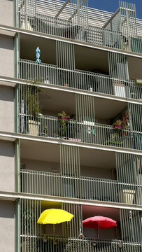 Balconies with colorful umbrellas and potted plants in a sunny day
