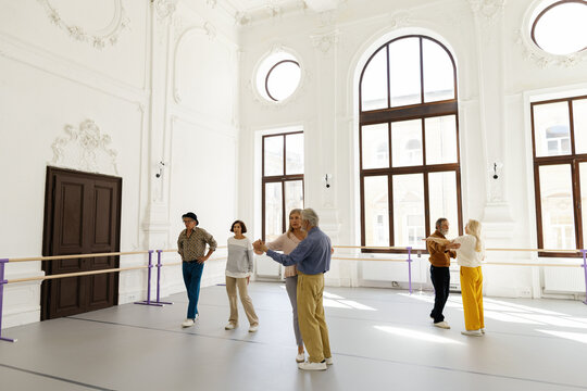 Pairs of old people developing dance skills at dance school