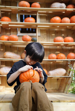 A Chinese boy holding a pumpkin and playing