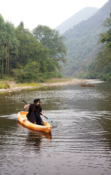 Asian woman rowing in a stream in the forest outdoors