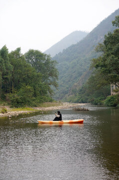 Asian woman rowing in a stream in the forest outdoors