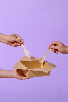 Hands Sharing a Sustainable Box and Wooden Utensils