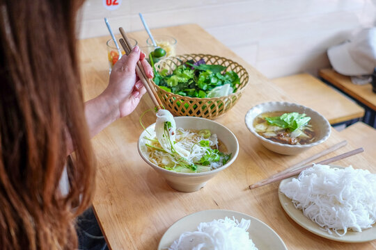 Side Profile of Woman Eating Vietnamese Noodles