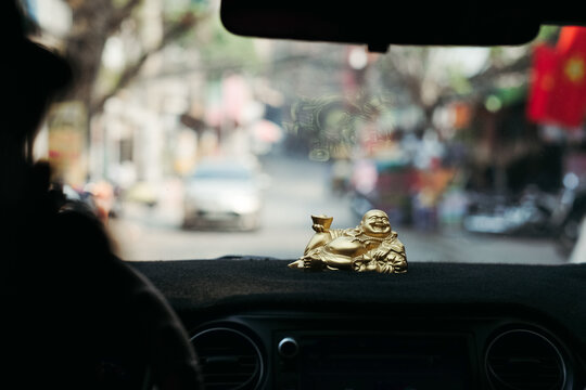 Golden Laughing Buddha Statue on a Car Dashboard