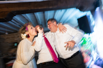 Guests singing karaoke and having fun at wedding party