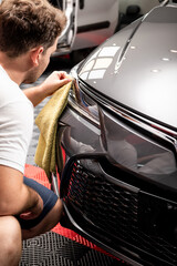 hombre limpiando opticas de automovil