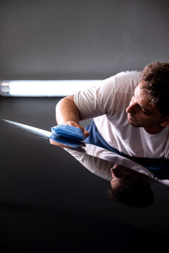 hombre aplicando tratamiento ceramico con pa&ntilde;o a mano en automovil