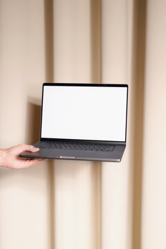 Hand Holding Laptop with white screen. Mockup laptop 