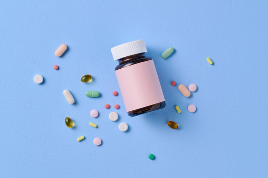 Colorful Pills and Medicine Bottle on Blue Background