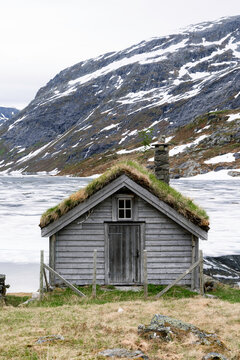 A barn on the side of a rocky mountain