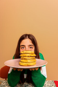 Girl Holding Plate of Pancakes