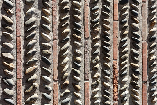 Close-up of decorative wall with vertical rows of smooth stones