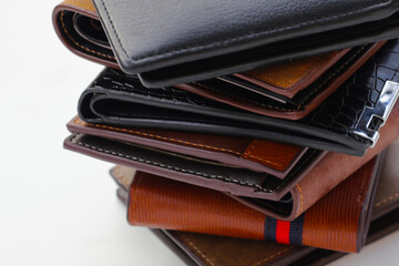 Stack of black and brown wallets on white background.