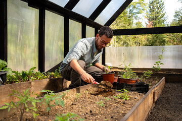 man gardening inside a greenhouse
