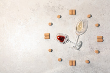 Corks and glasses of wine representing clock on light grey table, flat lay. Space for text