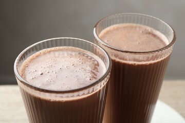 Tasty chocolate milk in glasses on table, closeup