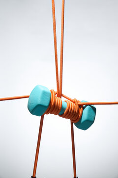 Suspended Blue Weights Tightly Wrapped in Orange Ropes