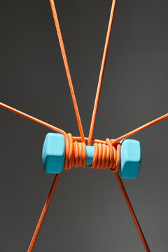 Abstract Composition of Ropes and Weights Against Gray Background